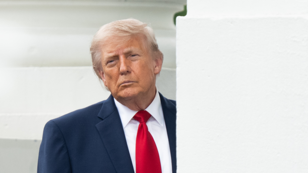 Donald Trump peeks out from behind a column.