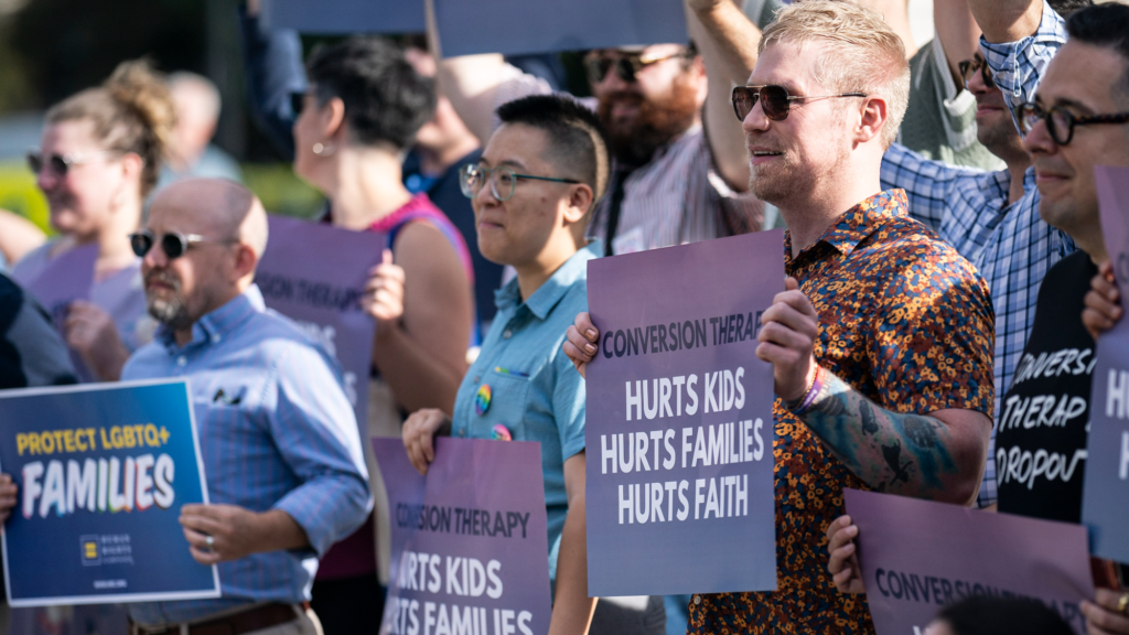 A sign reads: Conversion therapy hurts kids hurts families hurts faith.