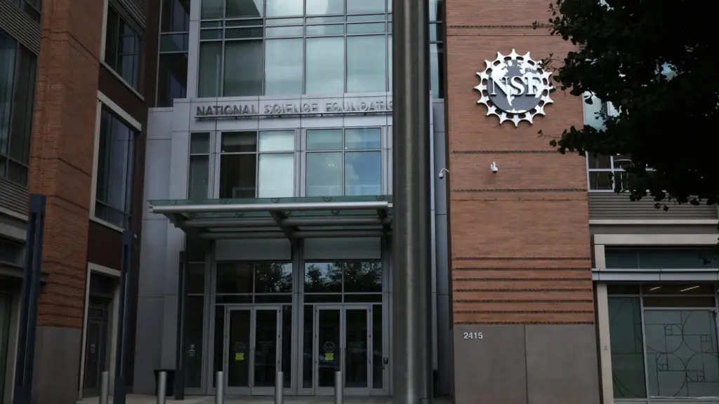 The front of a brick building with a glass door and the emblem of the NSF on the side.
