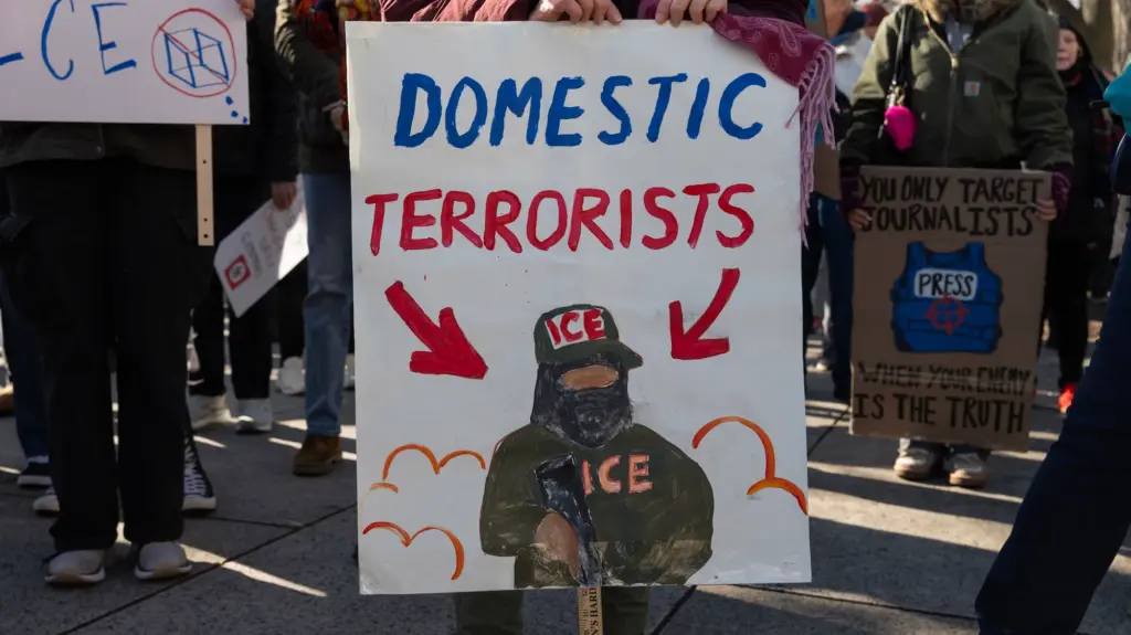 An activist holds a sign that reads 