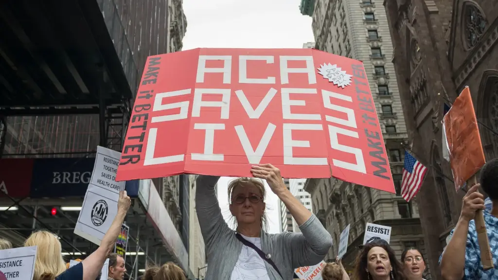 A woman holding up a poster at a protest that says 