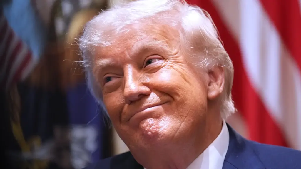 Donald Trump smirking in a blue suit and white shirt.
