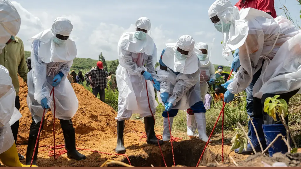 workers in hazmat suits dig a grave