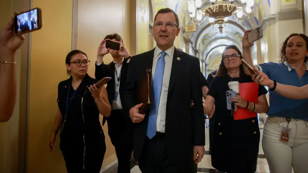 Rep. Tom Kean Jr., a white man in a suit, surrounded by reporters.