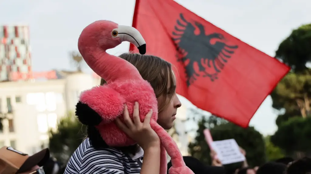 A protester holds a stuff flamingo