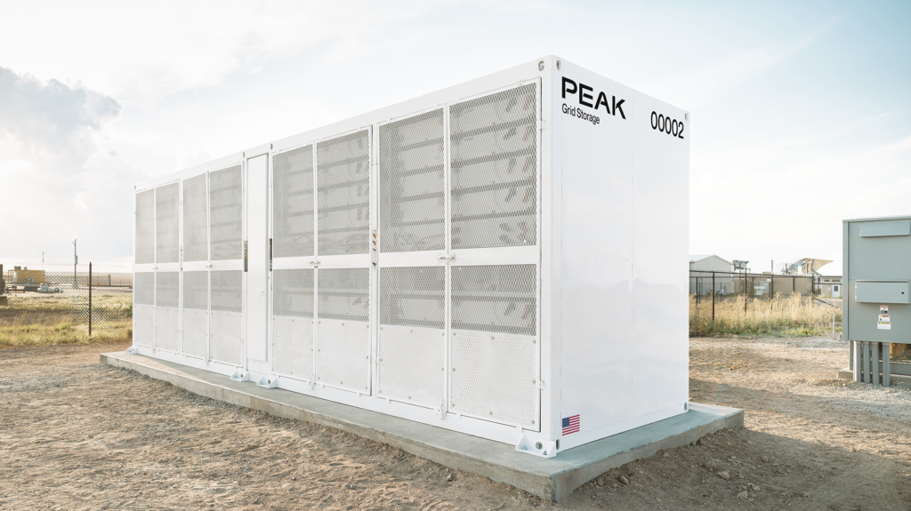 White rectangular sodium-ion battery sits outside on top of light brown dirt.