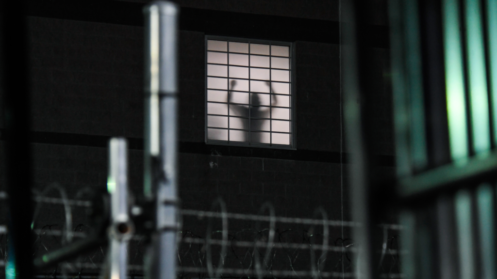 A person silhouetted against the windows of Delaney Hall.