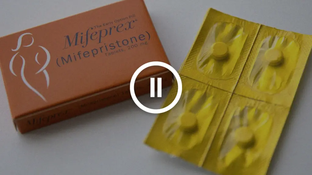 A box of Mifepristone pills, overlaid with the pause symbol