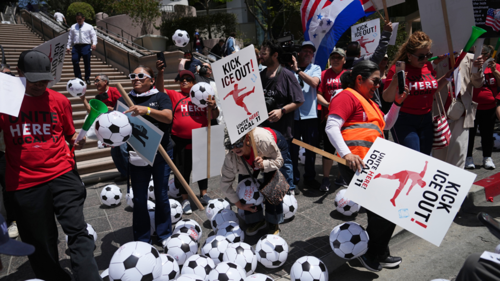 Over a dozen workers, many of them wearing red shirts saying 