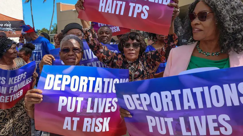 A group of Haitian women hold signs in protesting the deportation of immigrants with Temporary Protected Status.