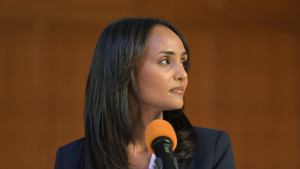 Melat Kiros looks to the right. She's sitting in front of a microphone.