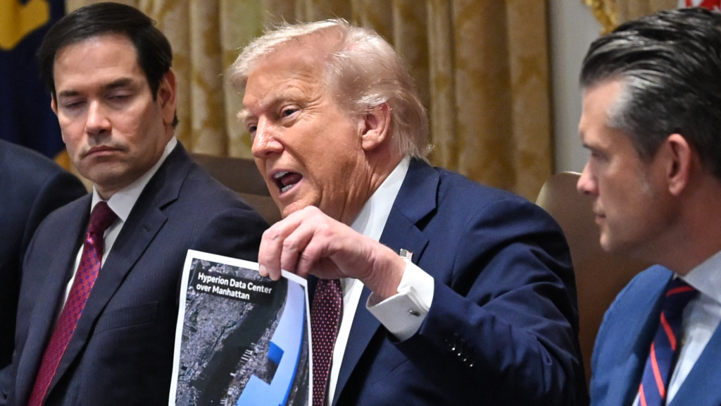 Trump is holding a piece of paper with the words 