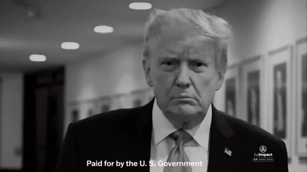 Donald Trump is shown in close-up walking through a hallway in a screenshot of an advertisement. The ad is in black and white and the words 