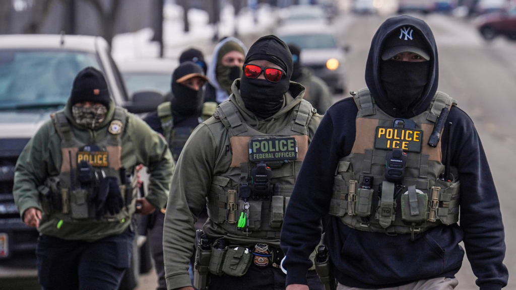 Federal agents walk down a street while conducting immigration enforcement operations in Minneapolis, Feb. 5, 2026.