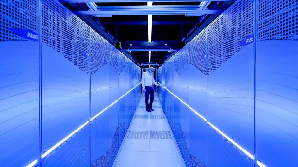 A man stands between two blue lit-up walls.
