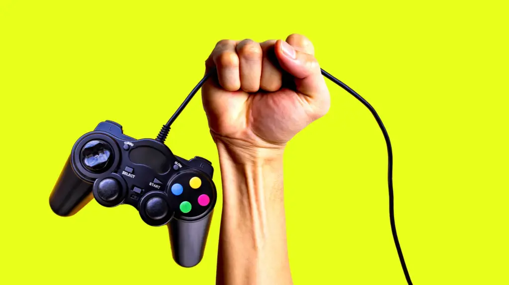 Conceptual illustration of a raised fist, clenched around the cord of a video game controller that hangs down below