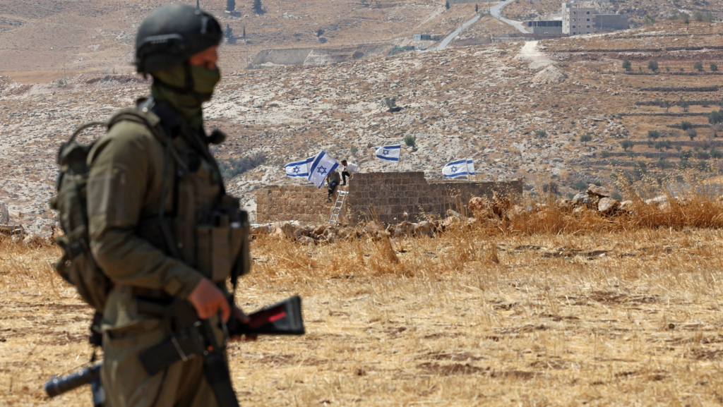 PALESTINIAN-ISRAEL-CONFLICT-WEST BANK-SETTLERS An Israeli soldier stands against the backdrop of a house seized by Israeli settlers in Beit Sahur, south of Bethlehem, in the occupied West Bank on August 14, 2026.