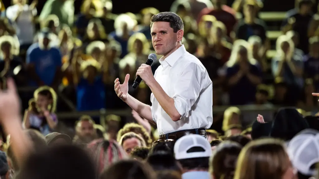 James Talarico standing among a crowd of people, speaking into a microphone.