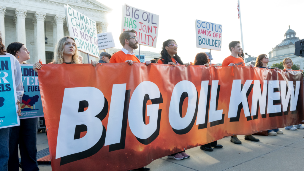 Group of young people hold an orange sign saying