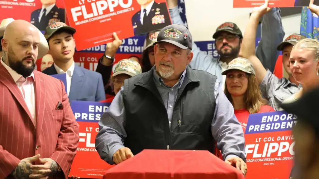 David Flippo wearing a hat with a Bronze Star on it and speaking at a campaign event.