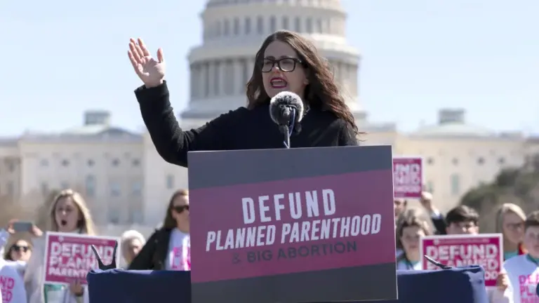 Kristan Hawkins stands at a lectern that reads