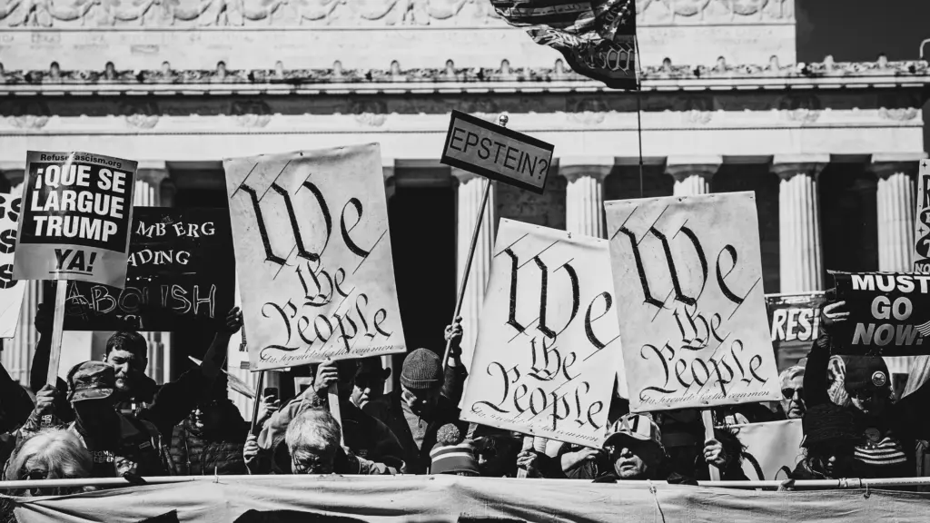 A photo of demonstrators holding signs in front of the Lincoln Memorial. Among the signs are banners that read 